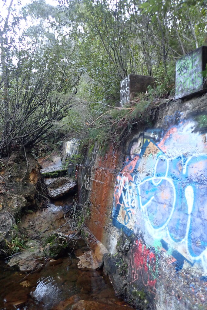 Closer view of retaining wall with graffiti.